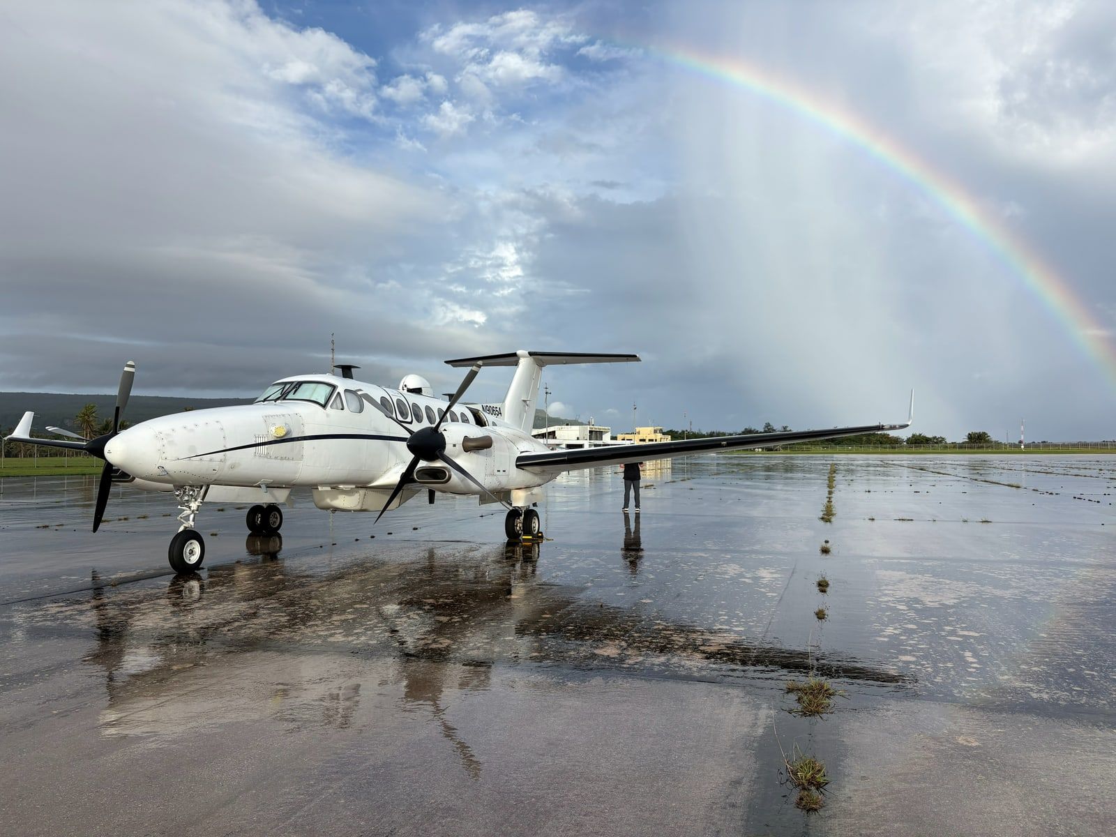 King Air 350ER head on under a full rainbow on a wet island ramp